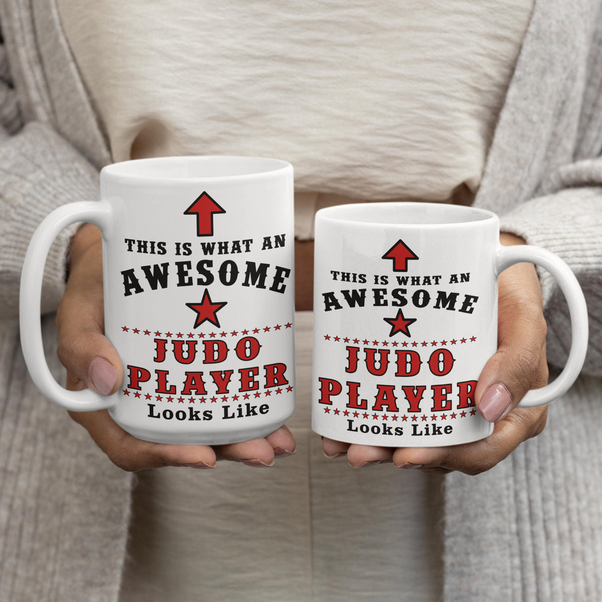Side-by-side comparison of the large 15oz and standard 11oz ceramic Judo Player mugs held by hands