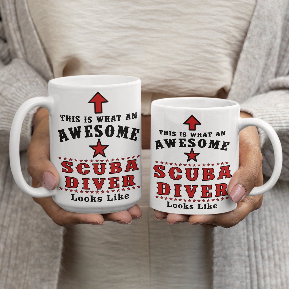 Two "This Is What An Awesome Scuba Diver Looks Like" white mugs with red and black text held side by side, showing 15oz and 11oz size comparison
