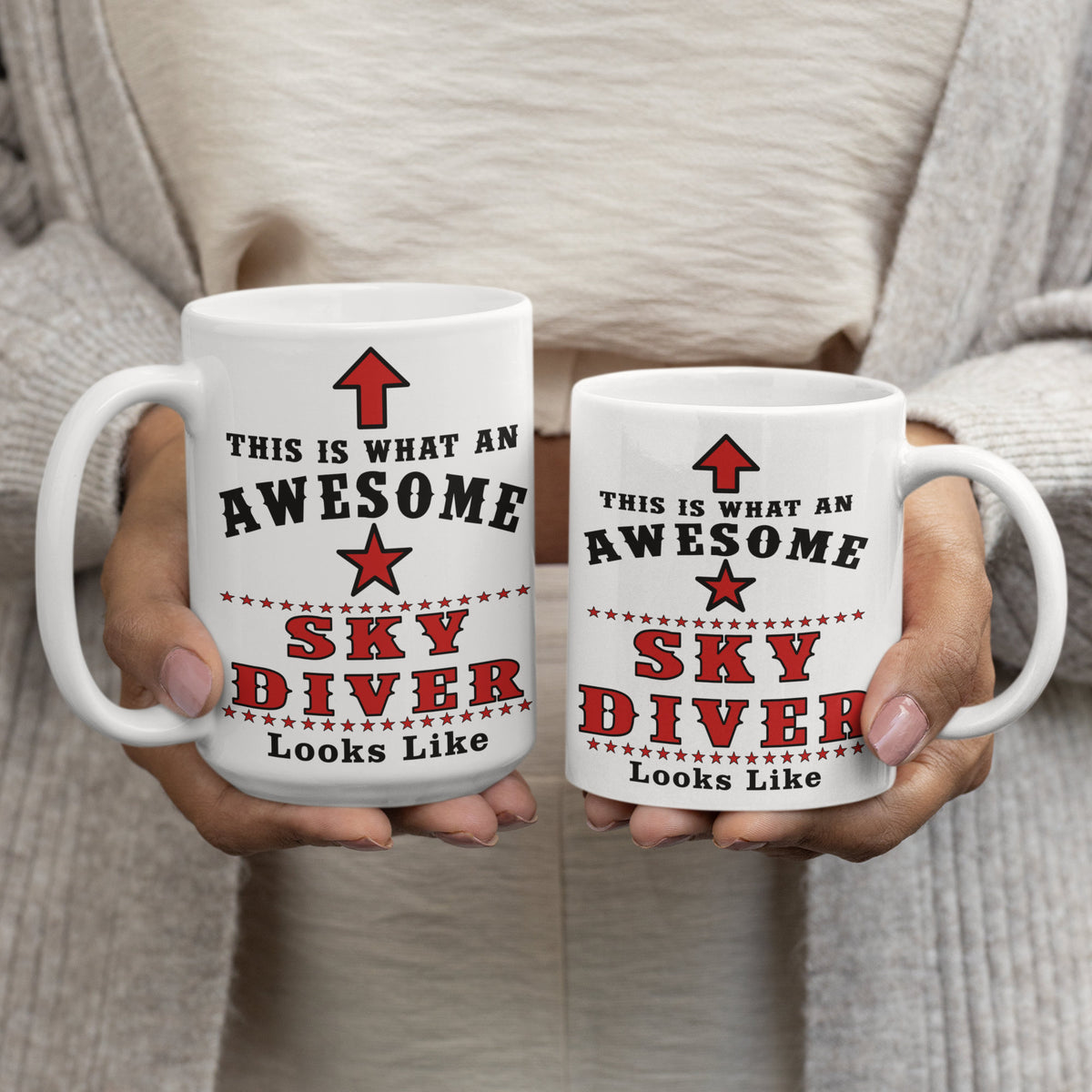 Woman holding two "This Is What An Awesome Sky Diver Looks Like" mugs, showing 15oz and 11oz size comparison