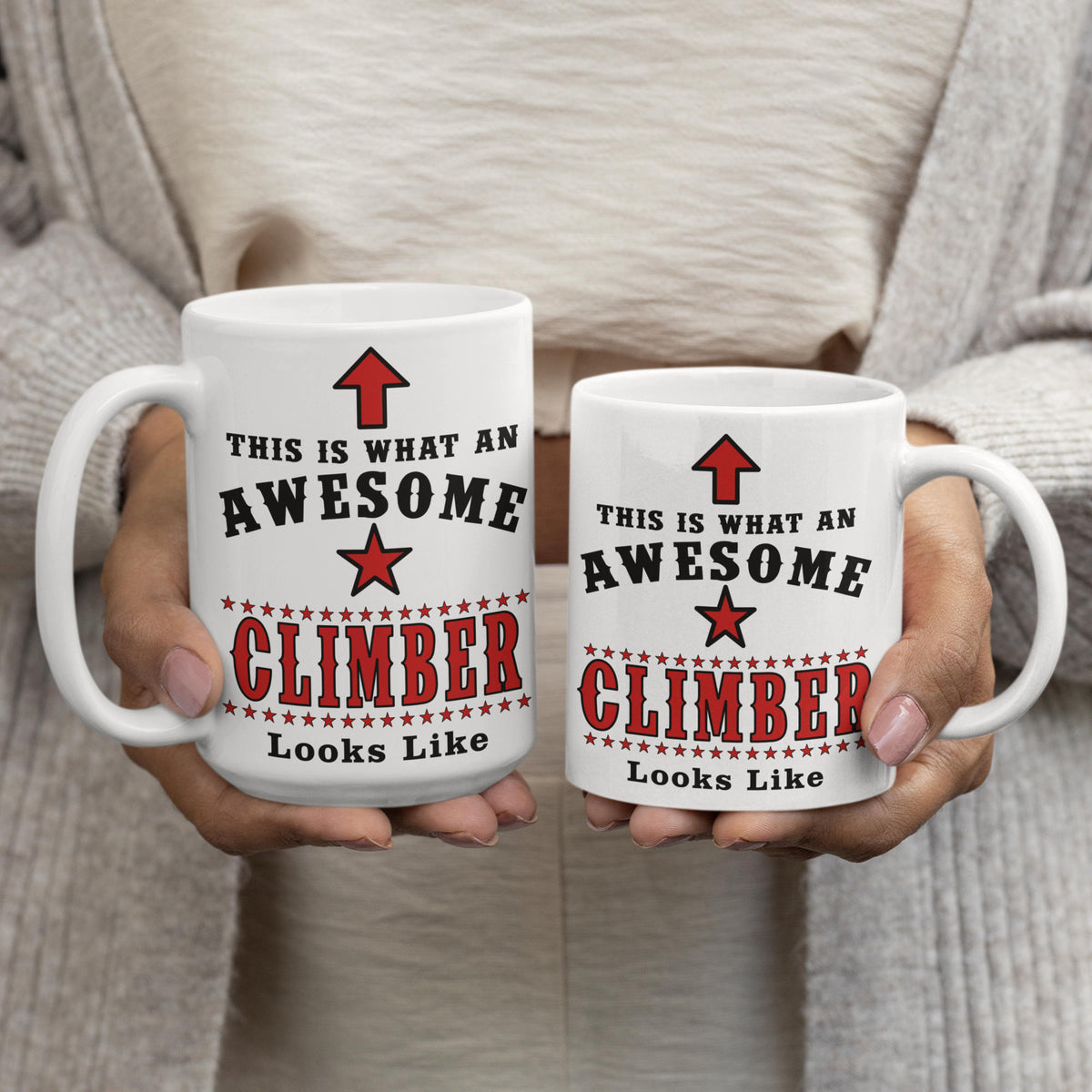 Side-by-side comparison of 15oz and 11oz "Awesome Climber" mugs being held, showing size difference