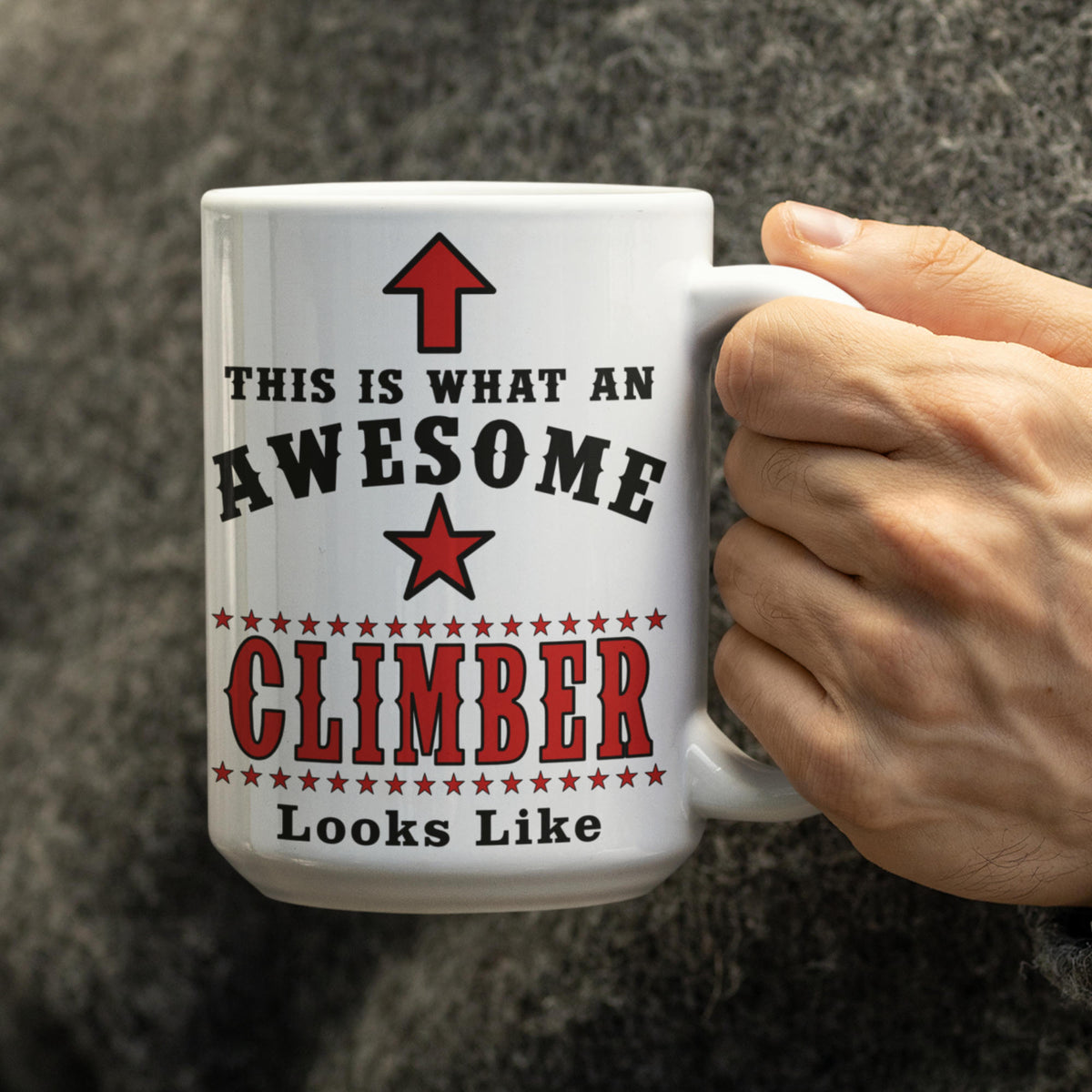 Person holding a white 15oz mug printed with "This Is What An Awesome Climber Looks Like" in black and red text