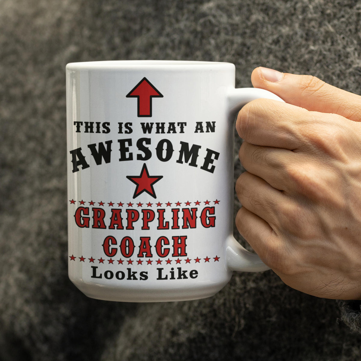Hand holding the Awesome Grappling Coach 15oz mug, showing full text design close up