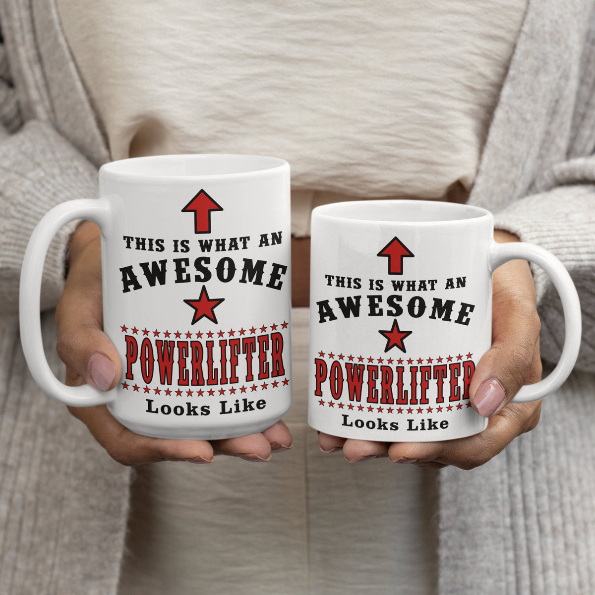 Two "This Is What An Awesome Powerlifter Looks Like" mugs held side by side, comparing the 15oz and 11oz sizes