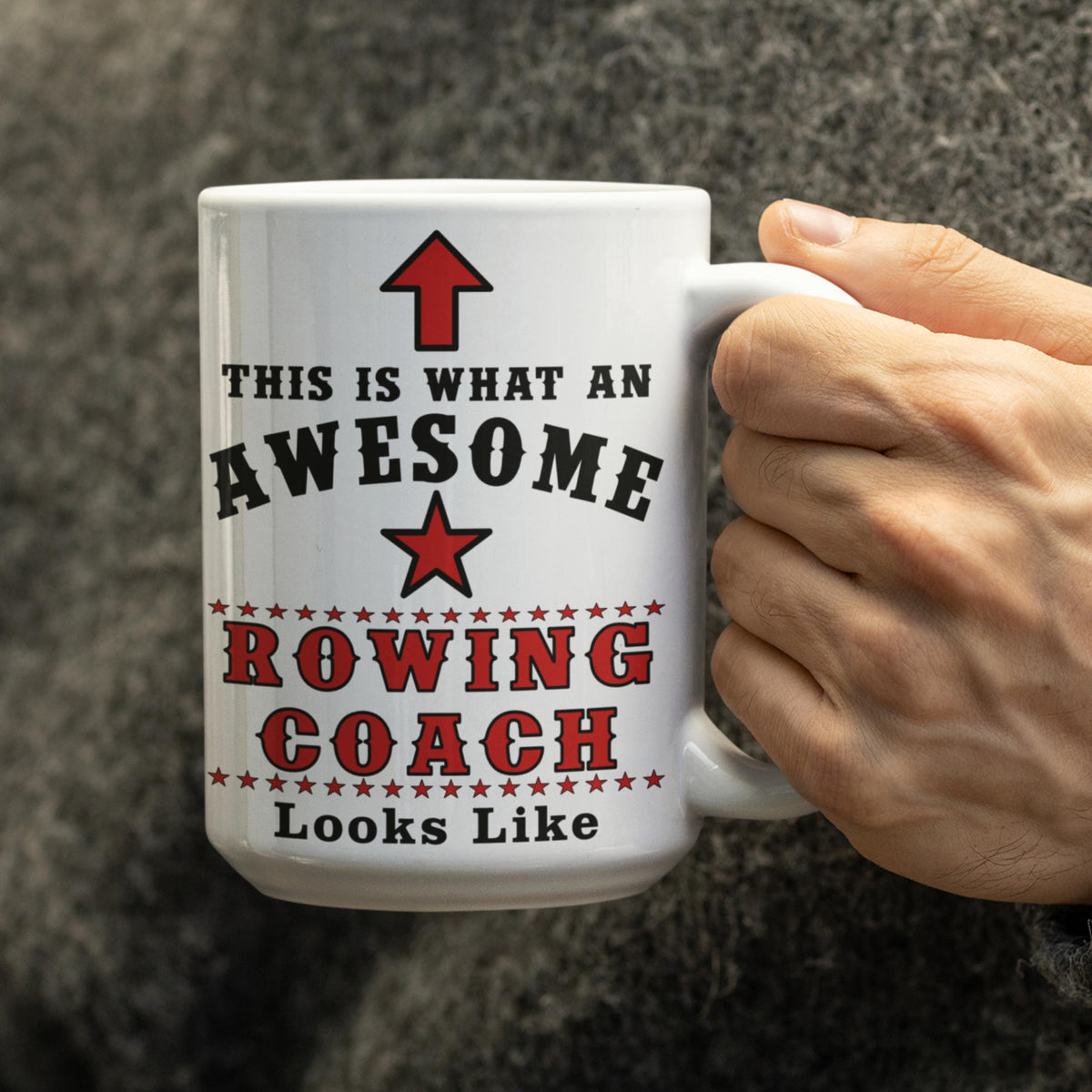 Hand holding a white 15oz "This Is What An Awesome Rowing Coach Looks Like" mug with red star design