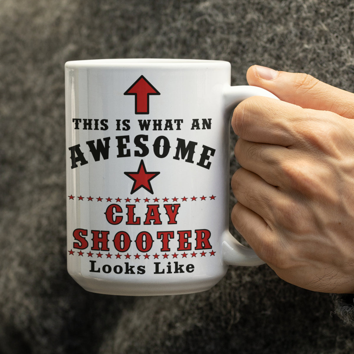 Hand holding a white 15oz mug printed with "This Is What An Awesome Clay Shooter Looks Like" in red and black