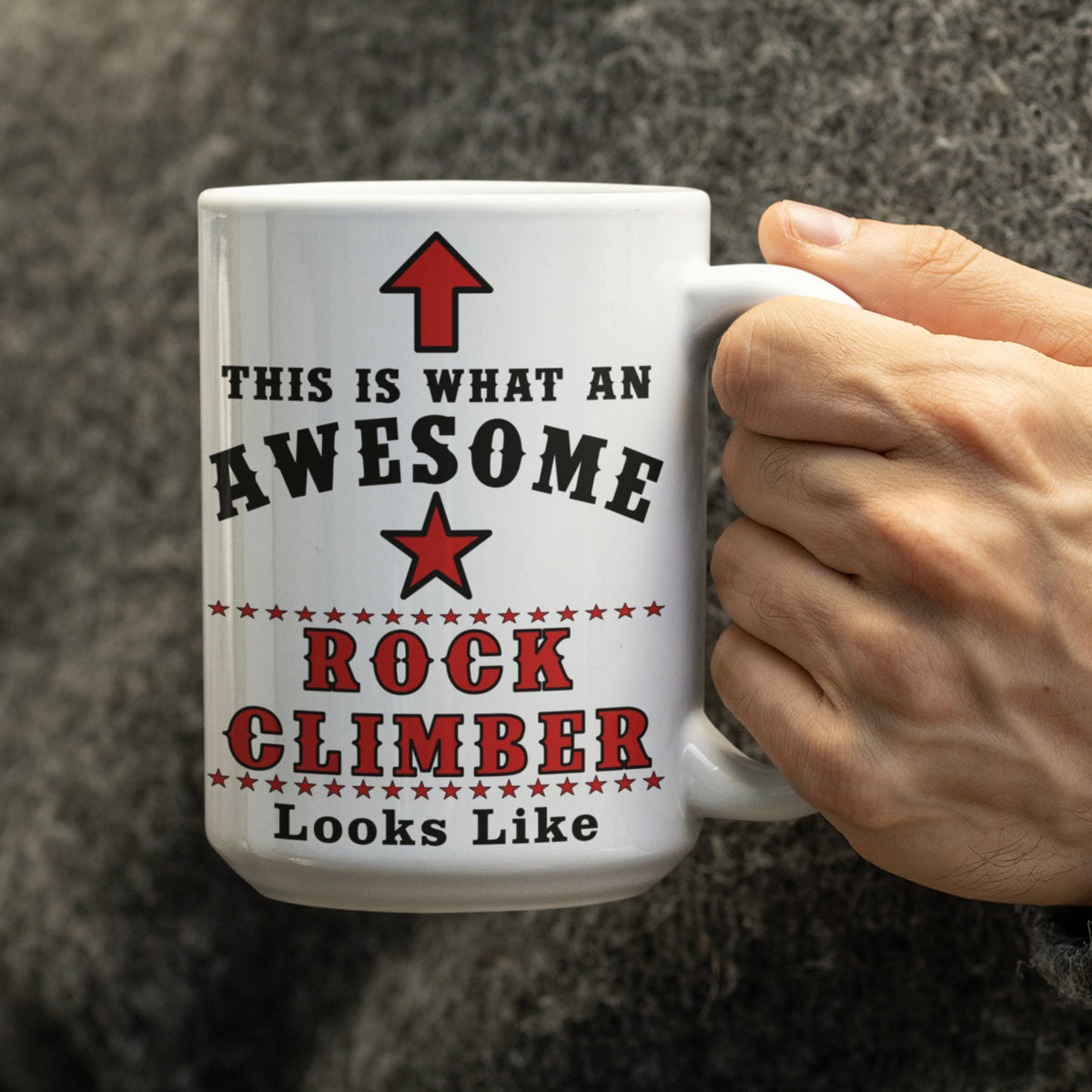 Close-up of 15oz Awesome Rock Climber mug held in hand, showing red arrow and star design