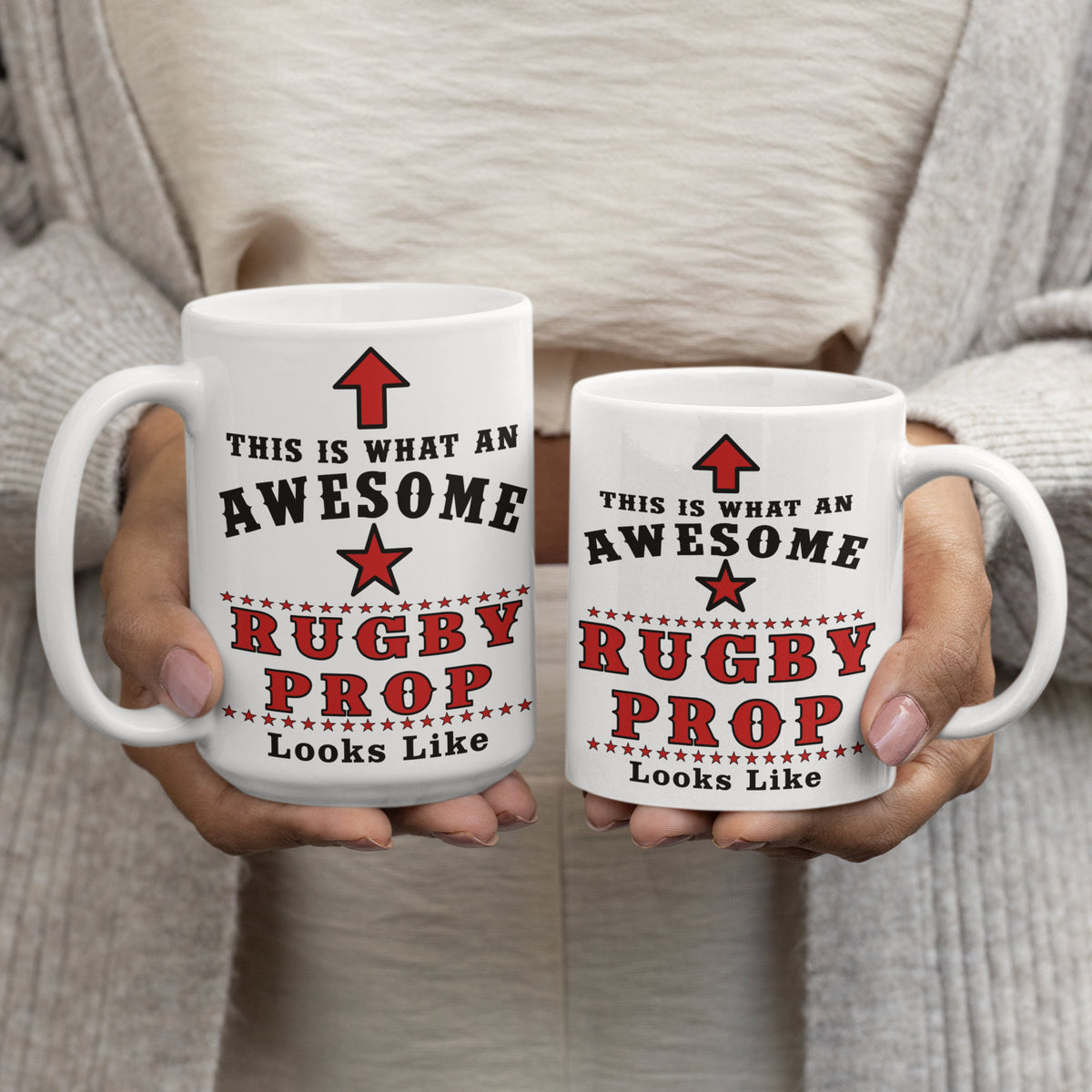 Two white 15oz mugs printed with "This Is What An Awesome Rugby Prop Looks Like" held in a woman's hands, showing 15oz and 11oz size comparison