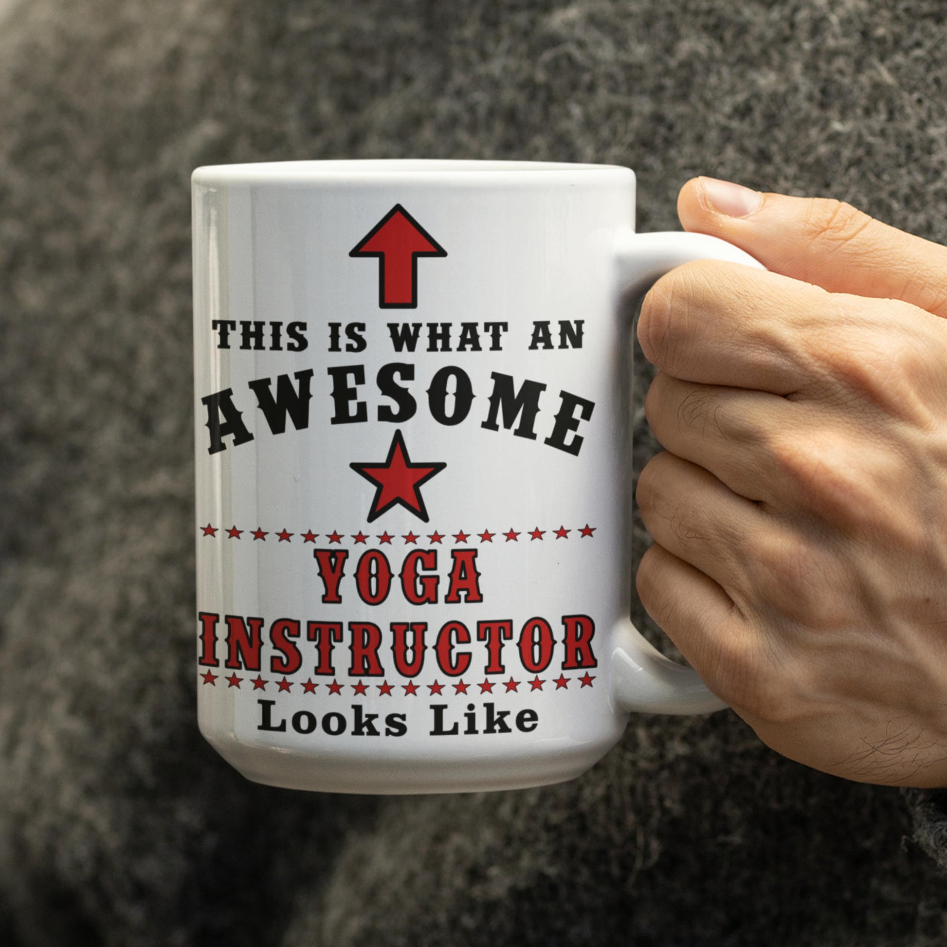 Hand holding 15oz "This is what an awesome Yoga Instructor looks like" mug with red arrow and star design

