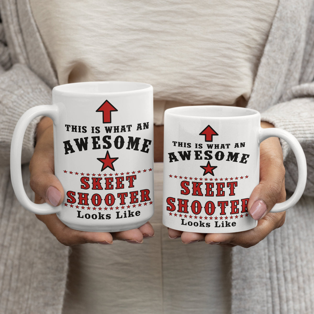 Woman holding two Awesome Skeet Shooter mugs, comparing the 15oz and 11oz sizes side by side